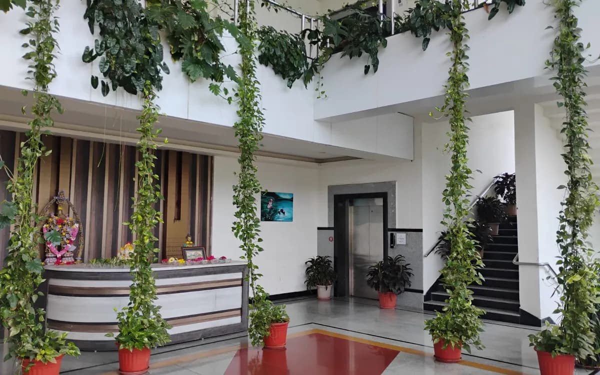 The plant-filled atrium of the Symbiosys campus, with the reception and staircase