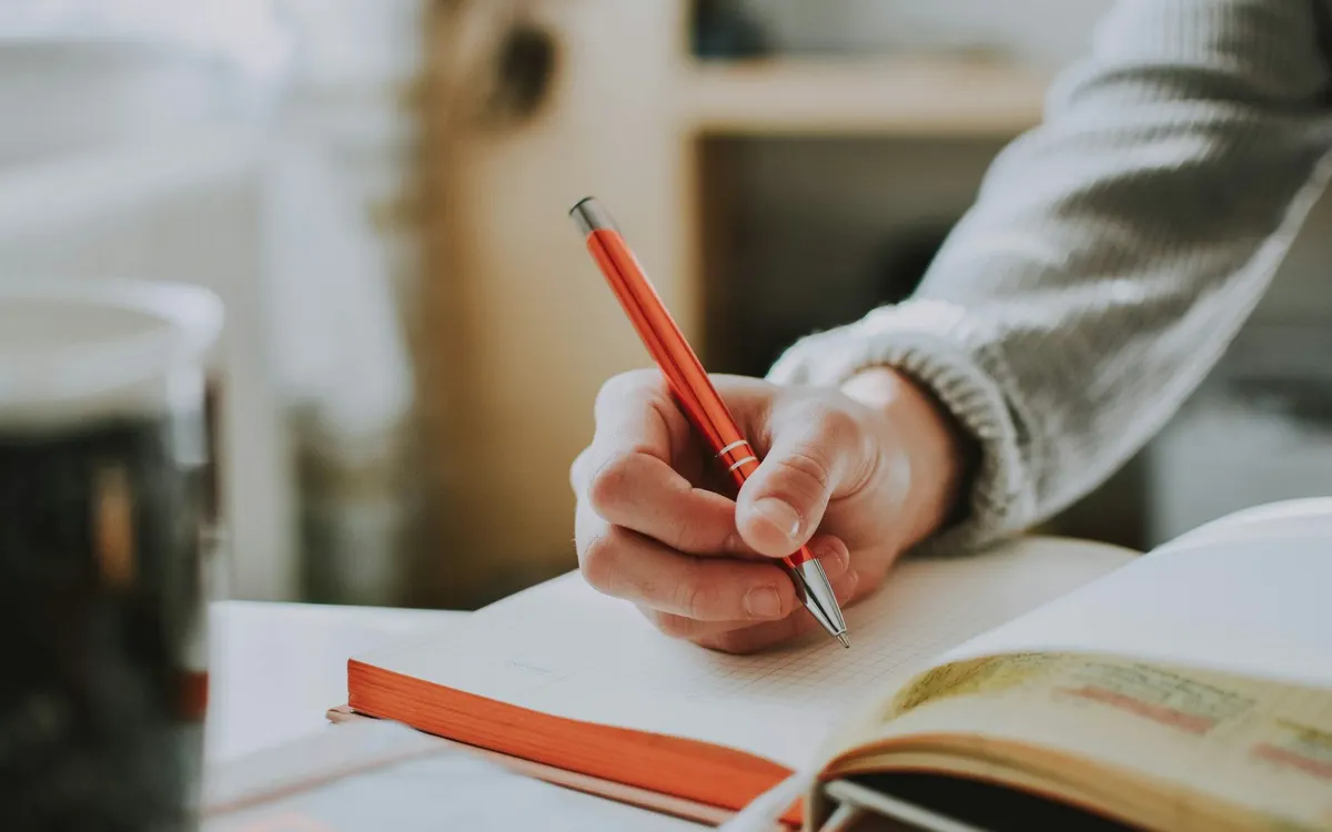 An editor marking up a book with a red pen