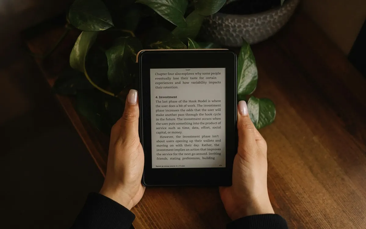Hands holding an e-reader showing a page of text